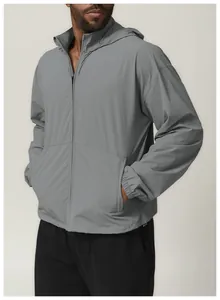 Side profile detail of a men's lightweight gray water-resistant hooded windbreaker.