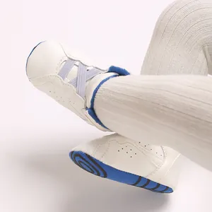Macrodetail van witte hoge babyschoenen met zachte blauwe zolen en PU-leermateriaal