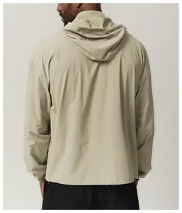 Rear view of a men's beige hooded windbreaker featuring water-repellent fabric detail.