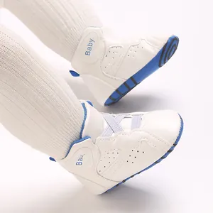 Detailopname van witte hoge babyschoentjes met zachte zool en blauwe accenten