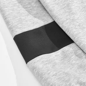 Macro-overzicht van zware grijze sweatshirtstof met zwart kleurblokpaneel