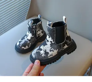 Gros plan de bottines de camouflage pour enfants avec semelles épaisses antidérapantes.