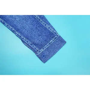 Detail close-up of long sleeve cuff with faux denim print texture and button fastener