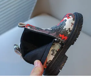 Détail de bottes camouflage enfant montrant le zip latéral et la semelle antidérapante.