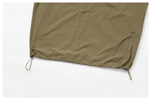 Detail view of the adjustable drawstring hem on olive green sports windbreaker jacket