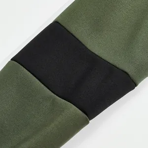 Detailopname van een olijfgroene en zwarte mouw op een zware katoenen polo-sweatshirt