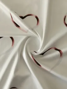 Detailed macro view of high-quality soft white knit fabric with romantic heart prints