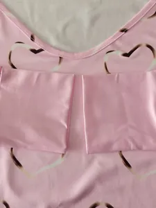 Macro detail view of pink women's t-shirt featuring heart print and smooth fabric texture
