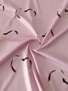 Macro view of soft pink fabric with artistic white and brown heart pattern print
