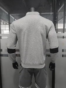 Achteraanzicht van een grijze zware polo-sweatshirt met lange mouwen en zwarte contrastbanden.
