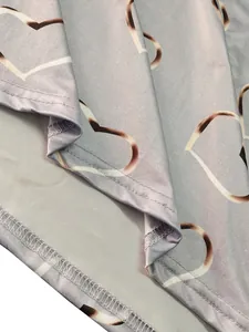 Close-up of heart print pattern and fine double-stitched hem on grey knit fabric