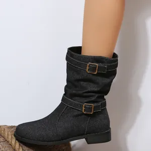 Seitenansicht der schwarzen Denim-Stiefel mit modischen Doppelschnallen-Riemen