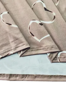 Detailed close-up showing heart print fabric and hem stitching on long-sleeve T-shirt