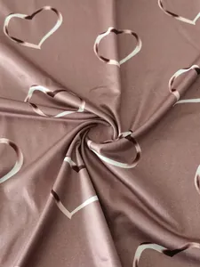 Close-up view of soft mauve knit fabric with stylized white heart patterns for T-shirt
