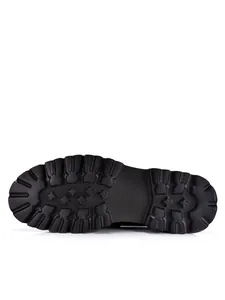 Detailed view of black chunky loafer's durable lugged rubber outsole traction pattern