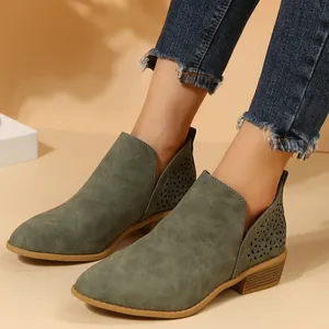 Detailopname van groene Chelsea boots met bloemige lasergesneden patronen op de hiel