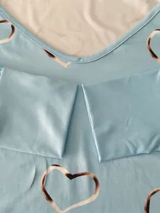 Macro detail view of V-neckline and fabric texture on light blue heart print long sleeve T-shirt