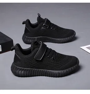 Gros plan de baskets de course noires respirantes pour enfants avec scratch et mesh.