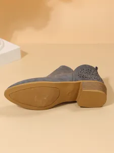 Gedetailleerde weergave van grijze Chelsea boot met focus op de getextureerde zool