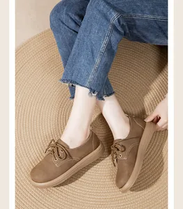 Primo piano di una modella che indossa scarpe vintage marroni su un tappeto intrecciato