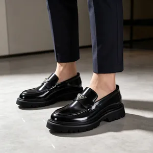 Close-up of stylish black patent leather platform loafers featuring triangular metal logo detail