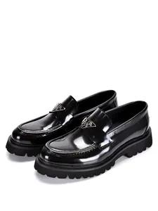 Close-up of black patent leather chunky loafers with silver triangle logo detail