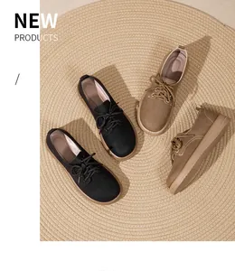 Scarpe basse invernali retrò calde foderate in pile nero e kaki su un tappeto di paglia.