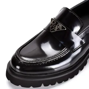 Premium black patent leather platform loafers featuring a triangular metal plaque