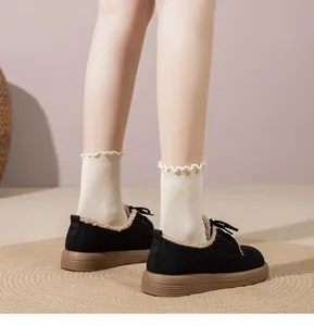 Vista posteriore di scarpe platform nere con calda fodera in peluche e suole marroni