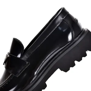 Premium men's black patent leather loafers with thick platform sole and triangle logo detail