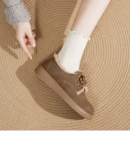 Scarpe invernali scamosciate marroni con calda fodera in pile su tappeto in juta.