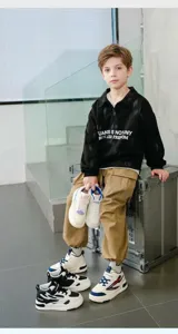 Modische halbhohe Kindersneaker, präsentiert von einem Jungen in einer trendigen Szene