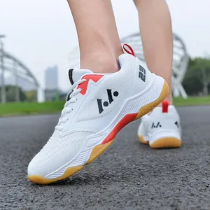 Vista dettagliata delle scarpe da badminton bianche leggere con accenti rossi e gomma.