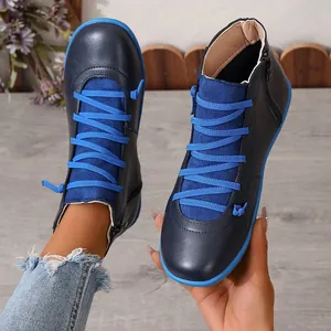 Close-up of navy blue high-top boots with vibrant blue laces and durable flat soles