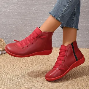 Vibrant red high-top Martin boots with side zipper and decorative laces on mat