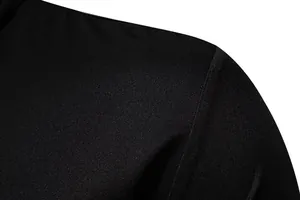 Primer plano detallado de la costura del hombro y tela negra lisa de camisa de hombre.