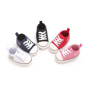 Gros plan sur des baskets souples en toile pour bébé en blanc, bleu, noir, rouge et rose