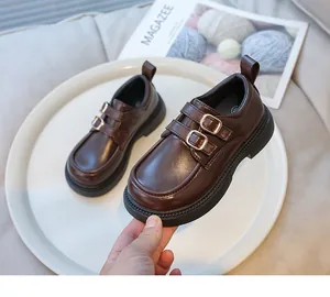 Vista dettagliata dei mocassini in pelle marrone stile inglese per bambine con fibbie oro.