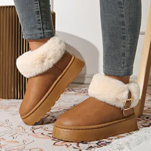 Detail of brown platform snow boots featuring fluffy faux fur trim and side buckle.
