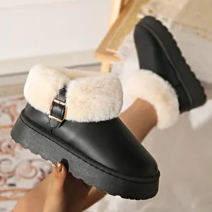 Close-up of black platform snow boots with beige faux fur lining and gold buckle detail