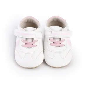 Draufsicht auf weiße Lauflernschuhe für Babys mit rosa Akzenten und Klettverschluss