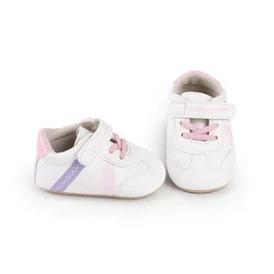 Detailaufnahme weißer Lauflernschuhe für Babys mit rosa Akzenten und Klettverschlussriemen