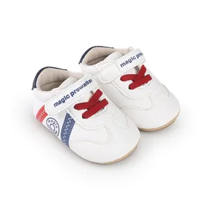 Weiße Baby-Lernlaufschuhe mit roten Schnürsenkeln und magic prewalker Schriftzug.