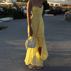 Detail showing a yellow mesh ruffled camisole maxi dress in a sunset resort environment