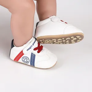 Detailansicht weißer Baby-Lauflernschuhe mit roten Schnürsenkeln und rutschfester Sohle
