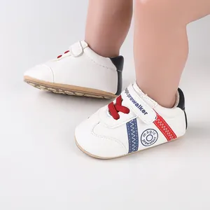 Detail der weißen Baby-Lauflernschuhe mit roten Schnürsenkeln und Klettverschluss