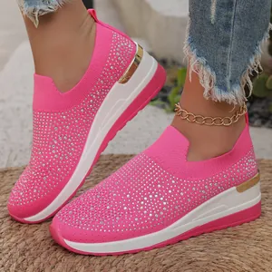 Detailaufnahme der pinken Keil-Sneaker mit Strasssteinen und goldenem Fersenakzent