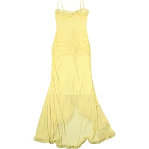 Close-up of pale yellow mesh maxi dress featuring ruffled hem and ruched design