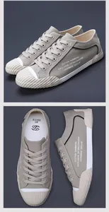 Detailansicht von modischen khakifarbenen Herren-Stoffschuhen mit weißer Gummikappe