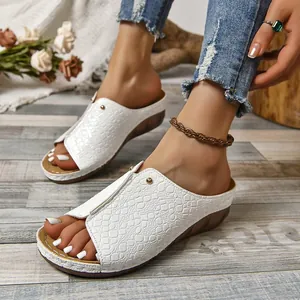 Primer plano detallado de sandalias blancas de cuña con patrón de cocodrilo para mujer
